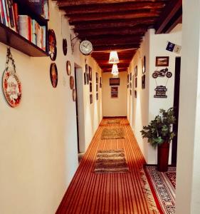 a hallway of a building with a long floor and clocks at The Nomad's Cottage-Losar , nearest hotel stay to visit Chandra Tal - Lake , in Spiti Valley in Losar