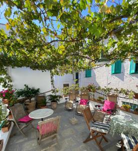 a patio with chairs and tables under a tree at NOVECENTO in Monopoli