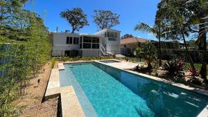 a swimming pool in front of a house at The Bay Haus - Luxury Escape so close to the Beach in Worrowing Heights