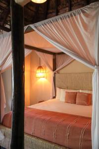 a bedroom with a bed with a canopy at Alquimia Hotel Boutique in Tulum