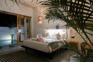 - une chambre avec un lit et une palmeraie dans l'établissement ANANA PRIVATE VILLA nusa penida, à Nusa Penida