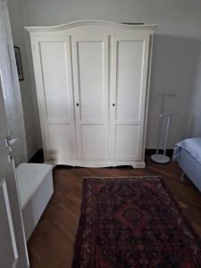 a white cabinet in a room with a rug at Il Paradiso all'improvviso in Vezzano Ligure +16 photos