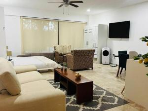 a living room with a couch and a bed at Spacious and comfortable apartment w pool and golf in Tulum