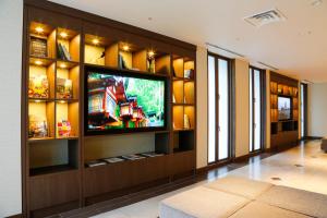 a living room with a flat screen tv on a wall at Hotel Keihan Tenmabashi in Osaka