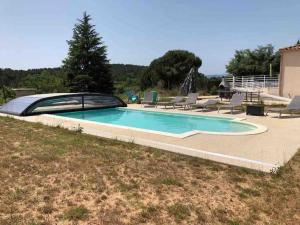 a swimming pool in a yard with chairs around it at Harmonia sur Moment-Ardeche-com in Rosières