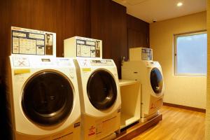 two washers and dryers in a laundry room at Hotel Keihan Tenmabashi in Osaka