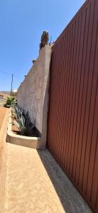 Una valla roja con algunas plantas al lado. en Los Chompolines 2, en Buena Vista
