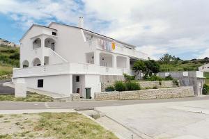 a large white building with a staircase on it at Apartments with parking space Metajna, Pag - 4127 in Zubovići