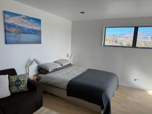 una camera da letto con un letto, un divano e una finestra di Mt Barker a Wanaka