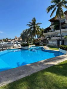 a large blue swimming pool next to a building at Marina-Access Apartment in peaceful Ixtapa in Ixtapa