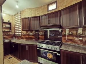 a kitchen with wooden cabinets and a stove at Top "OverView" Resort اطلالة القمة in Al ‘Āmirīyah