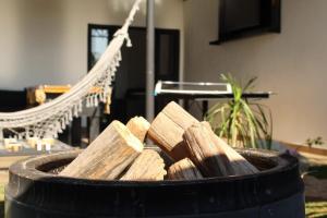 a barrel filled with wood in front of a hammock at casa com bela vista em Bragança Paulista in Bragança Paulista