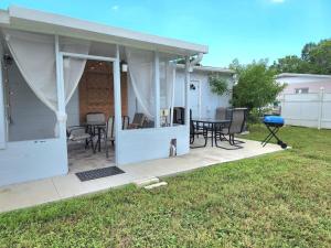a covered patio with a table and chairs at Charming And Cosy, Newly Remodeled St Petersburg in St Petersburg