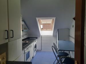 Una pequeña cocina con fregadero y estufa. en Cangas Alameda, en Cangas de Onís