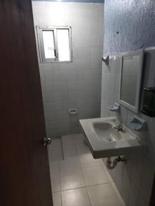 ein Badezimmer mit Waschbecken und Spiegel in der Unterkunft Departamento en el corazón de cozumel in Cozumel