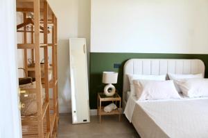 a bedroom with a bed with a green accent wall at Il Cortile del Borgo in Borgo Ticino