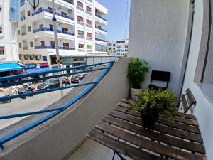 a balcony with a bench and a view of the beach at Miramar Martil à 2 min de la plage in Martil