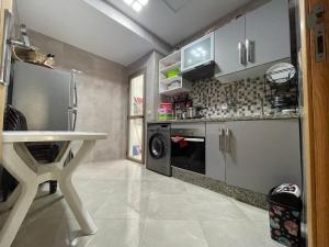 a kitchen with a washer and dryer and a table at Residence Rimal 5 Martil in Tétouan