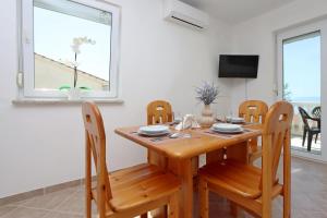 a dining room with a wooden table and chairs at Apartments with parking space Kostrena, Rijeka - 23422 in Kostrena