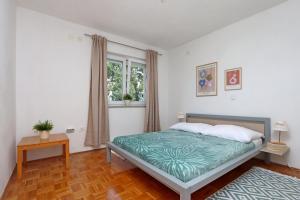 a bedroom with a bed and a window at Apartments with parking space Kostrena, Rijeka - 23422 in Kostrena