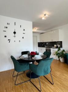 ein Esstisch mit Stühlen und einer Uhr an der Wand in der Unterkunft Modernes Apartment mit Balkon und Parkplatz Zentrum in Hannover