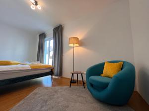 ein Schlafzimmer mit einem blauen Stuhl und einem Bett in der Unterkunft Modernes Apartment mit Balkon und Parkplatz Zentrum in Hannover