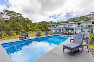 ein Swimmingpool mit Stühlen und ein Haus in der Unterkunft Mala o Kilauea Nature Retreat in Pahoa