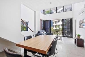 comedor abierto con mesa de madera y sillas en The Aubrey Boutique Apartments - Hosted by Coastal Letting Co., en Gold Coast