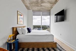 a bedroom with a large bed and a window at Rainey St 1BR - Heated Pool - Gym - Bar - DT ATX in Austin