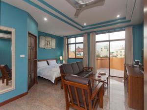um quarto com uma cama, um sofá e uma secretária em Pattaya Garden Apartments Boutique Hotel em South Pattaya