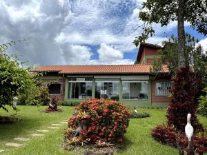 a house with a swan in front of a yard at Recanto do Coração in Itaúna