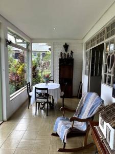 a screened in porch with a table and chairs at Recanto do Coração in Itaúna