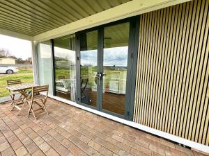 a screened in porch with a table and chairs at Field Tiny Home - Fruit & Sunset in Hall