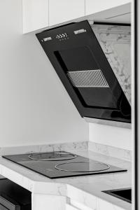 a stove top oven with a tablet on a counter at Field Tiny Home - Fruit & Sunset in Hall +12 photos