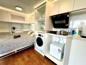 a small room with a bed and a microwave at Field Tiny Home - Fruit & Sunset in Hall