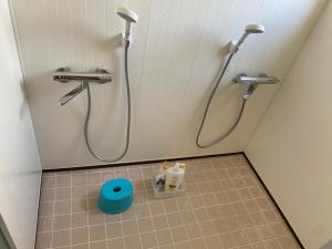 a bathroom with a shower with two faucets at Yoshidoku Inn - Universal Studios 3 stops, Namba 2 stops, Shinsaibashi 3 stops in Osaka