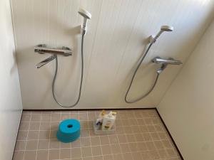 a bathroom with a shower and a tiled floor at Yoshidoku Inn - Universal Studios 3 stops, Namba 2 stops, Shinsaibashi 3 stops in Osaka