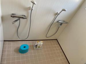 a bathroom with two shower heads and a tile floor at Yoshidoku Inn - Universal Studios 3 stops, Namba 2 stops, Shinsaibashi 3 stops in Osaka
