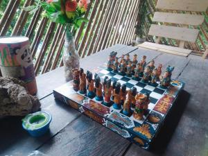 a chess board on a wooden table with a vase at Kakuna Lodge in Minca