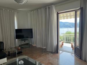 a living room with a sliding glass door to a balcony at Ranco Villa Lina in Ranco