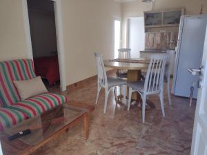 a living room with a table and chairs and a refrigerator at Bignonia's in Tornquist