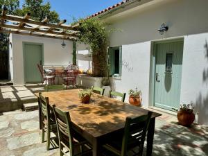 a wooden table and chairs on a patio at Olive Mill Cottage in Skopelos Town