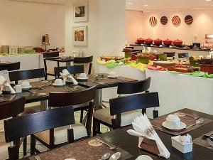 a dining room with tables and chairs in a restaurant at Mercure Recife Navegantes - Privado in Recife