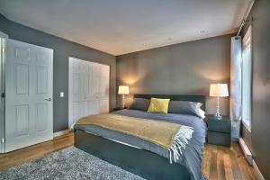 a bedroom with a large bed and two lamps at Dynamite 2-Bedroom House, Garage, Sleeps 6 in Sherbrooke