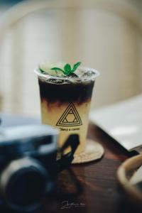 Ban Huai KhaiにあるAi-oon b2 by Triple a coffeeのカメラの隣のテーブルに置かれたコーヒーカップ