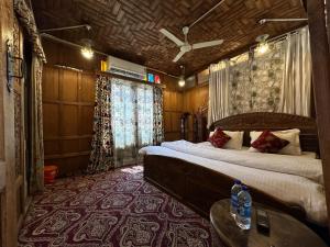 a bedroom with a bed and a table in a room at Lake Palace Group Of House Boats in Srinagar