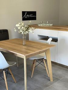 a wooden table with a vase of flowers on it at 3H MALARGUE Monoambiente in Malargüe