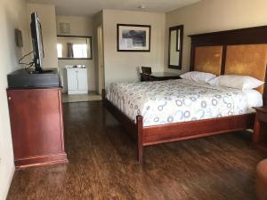 une chambre avec un lit et une télévision à écran plat dans l'établissement Great Western Inn & Suites, à Euless