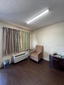 une salle d'attente avec une chaise et une fenêtre dans l'établissement Great Western Inn & Suites, à Euless