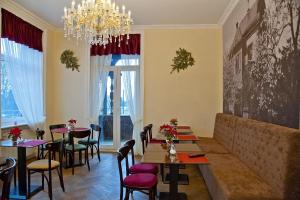 a restaurant with tables and chairs and a chandelier at Arena Villa am Wasserpark in Frankfurt/Main